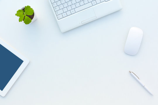 Asymmetrical Business Composition on White Office Desk with Flower