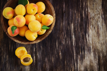 ripe apricots in a wooden bowl
