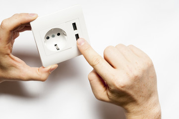 A man hold the electric socket with two usb-charger ports.