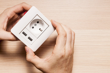 A man installs the decorating pane to  the socket with two usb c
