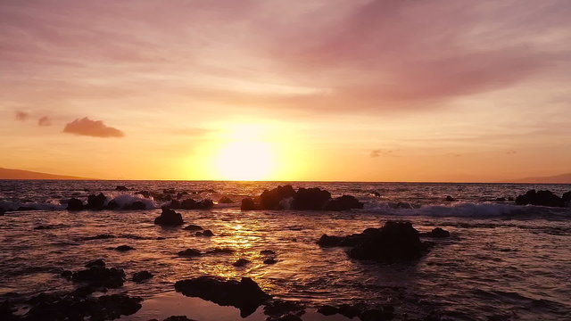 Amazing Dramatic Sunset View. Slow Motion Aerial Shot Flying Low into Horizon Over Water. Lava Rock Formations. 