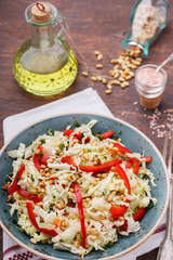 Salad from cabbage with red pepper and pine nuts.