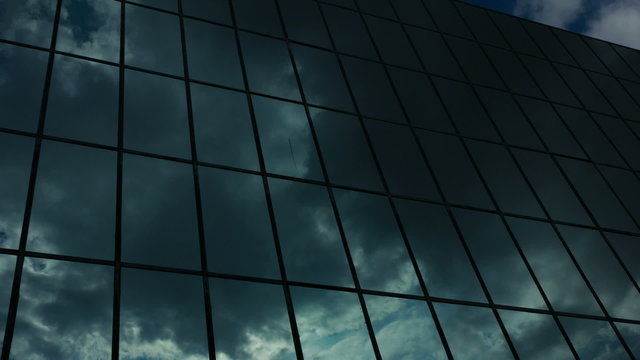 Glass skyscraper dark storm clouds reflection timelapse