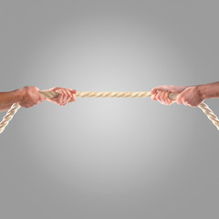 Hands of people pulling the rope on a gray background.  Competition concept