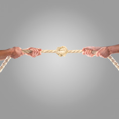 Hands of people pulling the rope on a gray background.  Competition concept