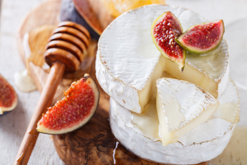 Brie cheese on a wooden Board with fresh figs and honey.selective focus.