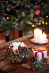 Fir branches decorated for the new year on dark wooden background. Christmas tree and candles, festive mood