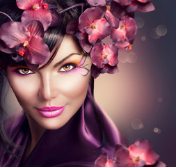 Beautiful woman with orchid flower hairstyle and creative makeup