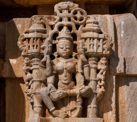 Obraz premium Vintage sculpture of Hindu goddess in carved stone wall of temple