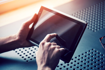 male hands holding digital tablet touching with finger