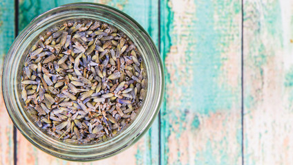 Dried lavender herbal tea in mason jar over wooden background