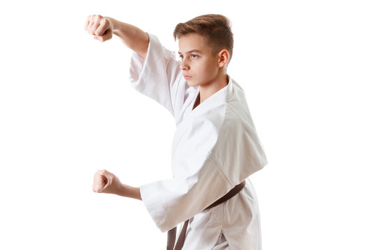 Martial art sport karate - child teen boy in white kimono training punch and block