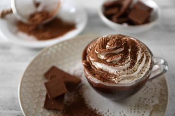 Cup of coffee with cream on color wooden background
