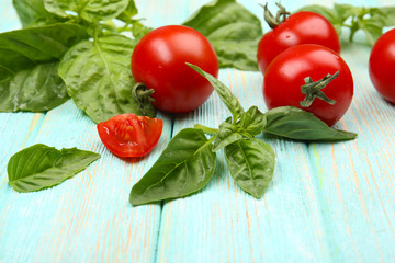 Fresh tomatoes with basil on wooden table close up