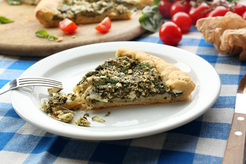 Slices of open pie with spinach and tomato cherry on table close up