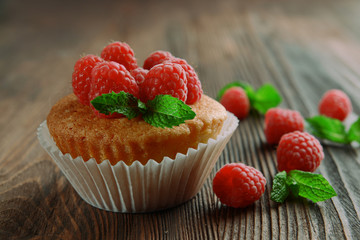 Delicious cupcake with berries and fresh mint on wooden table close up
