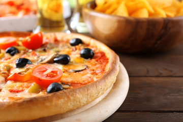Pizza served with beer on wooden table