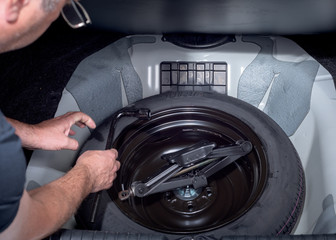 Spare tire with jack in trunk of a car