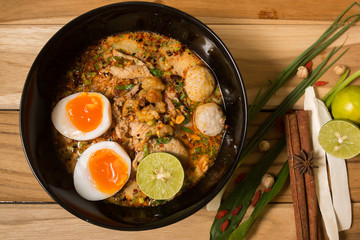 bowl of noodles with vegetables and soft boiled egg on wooden ta