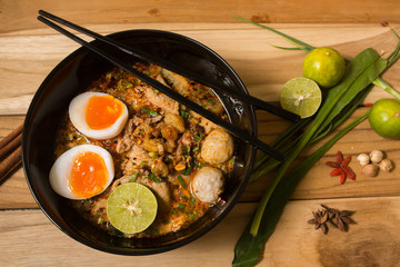 bowl of noodles with vegetables and soft boiled egg on wooden ta