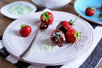 Served table with delicious strawberries in chocolate on wooden background