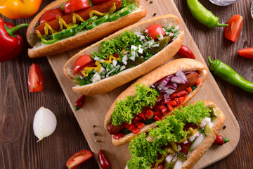 Hot dogs and vegetables on wooden cutting board