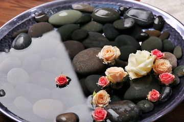 Obraz na płótnie Canvas Spa composition of flowers and stones in water, close-up