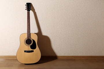 Acoustic guitar propped on wall in the room