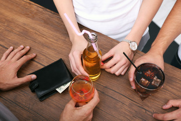 View on friends having alcoholic drinks in the bar, close-up