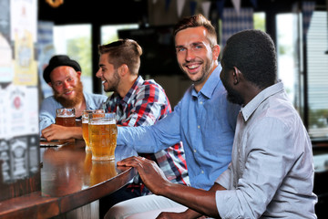 Young men drinking beer in pub
