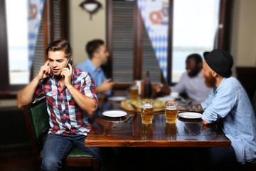 Young men drinking beer and talking in cafe