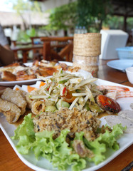 Spicy papaya salad serving with shrimp, boiled egg, porkball and