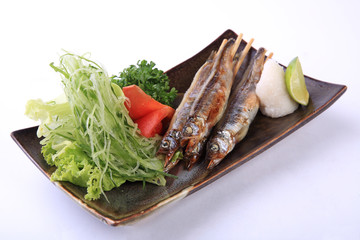 Grilled shishamo on ceramic dish isolated on white background