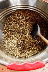 Coffee beans are roasting in pan. Traditional techniques.