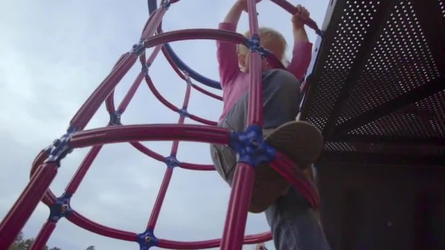 Cute little girl climbs all the way down a jugle gym