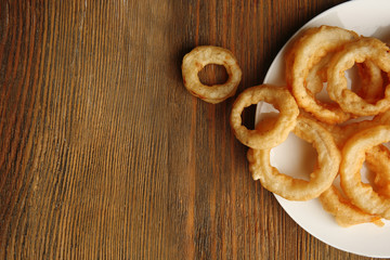 Chips rings on plate on wooden background