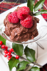 A beautiful chocolate dessert with festive holly and tartan plaid table decor