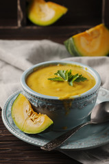 Pumpkin soup with parsley on vintage table