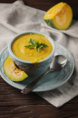 Pumpkin soup with parsley on vintage table