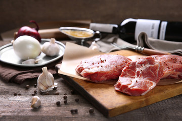 Marbled beef steak with bottle of wine and spices on wooden background