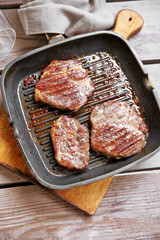 Roasted beef fillet on pan, on wooden background