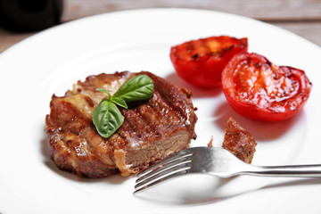 Roasted beef fillet on plate, on wooden background