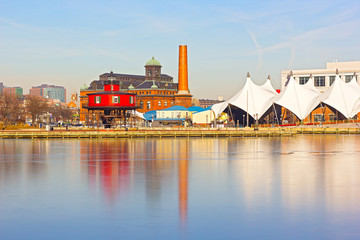 Baltimore waterfront with Seven Foot Knoll Lighthouse at sunset in winter. Colorful reflections of waterfront buildings at Inner Harbor in Baltimore, Maryland. - obrazy, fototapety, plakaty