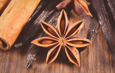 Vintage photo, Closeup of star anise, fragrant vanilla and cinnamon on wooden surface plank