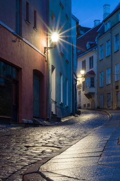 Fototapeta Illuminated narrow street at night in Tallinn Old Town, Estonia