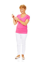 Smiling senior woman holding toothpaste and toothbrush