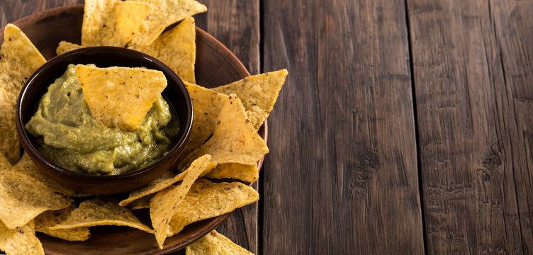 Guacamole sauce with corn chips from left side rustic