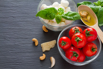 Caprese salad ingredients on dark stone background