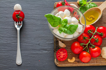 Caprese salad ingredients on dark stone background