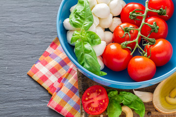 Caprese salad ingredients on dark stone background